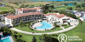 Image of businesswoman looking in telescope standing atop of rock